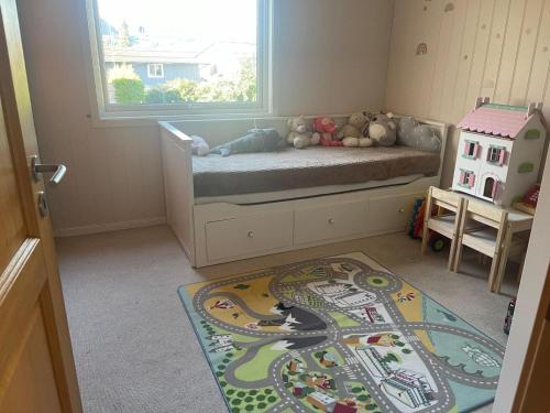 Dormitorio infantil con alfombra de tren en el suelo en Hus med hage og terasse, ideelt for familier en Lyngdal
