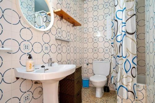 a bathroom with a sink and a toilet and a mirror at Can Sant Joan in Alcanar