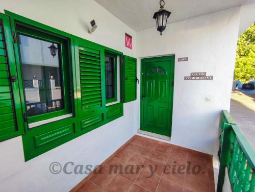 a room with green doors and windows on a building at Casa mar y cielo in Playa Blanca