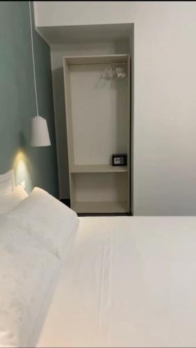 um quarto com uma cama branca e um espelho em DomusEli em Santa Maria di Castellabate