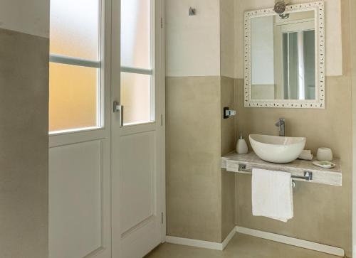 La salle de bains est pourvue d'un lavabo et d'un miroir. dans l'établissement Flower Rooms Cagliari, à Cagliari