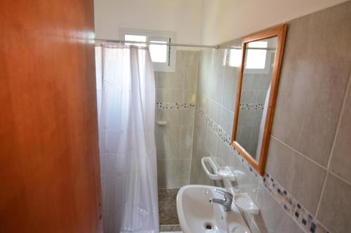 a bathroom with a sink and a shower with a mirror at hosteria las cachi alojamiento in Esquel
