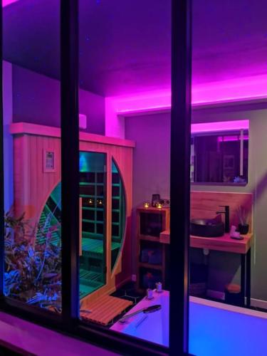 a room with purple lights and a fish tank at Cocon d'Evasion**** SPA PRIVATIF et ciels étoilés in Le Havre
