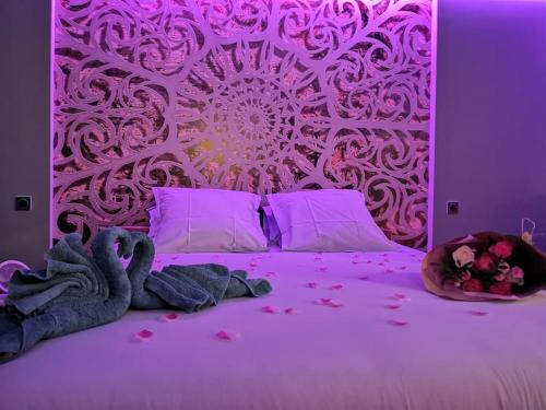 - une chambre violette avec un grand lit fleuri dans l'établissement Cocon d'Evasion**** SPA PRIVATIF et ciels étoilés, au Havre