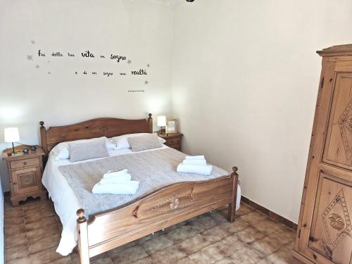 a bedroom with a bed with two towels on it at La casa del Gigante Frassino in Acceglio