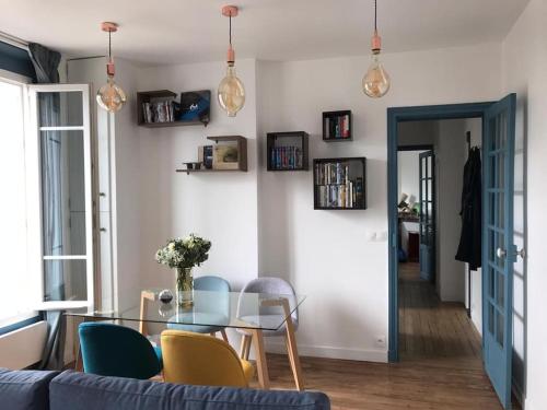 ein Wohnzimmer mit einem Glastisch und Stühlen in der Unterkunft Superbe appartement moderne et lumineux à Puteaux! in Puteaux