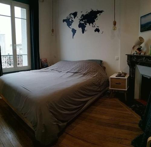 een slaapkamer met een bed met een kaart aan de muur bij Superbe appartement moderne et lumineux à Puteaux! in Puteaux
