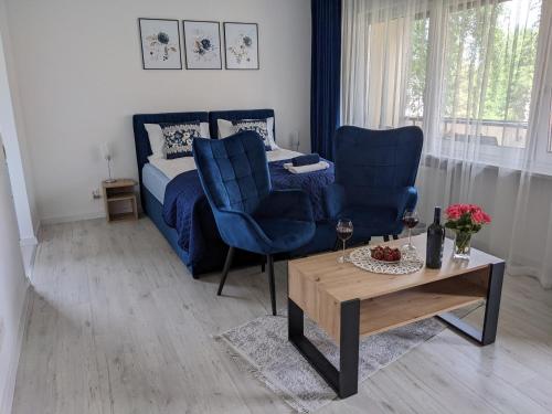 a bedroom with a bed and two chairs and a table at Apartament Piccolo in Kraków
