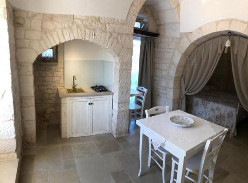 a living room with a table and a kitchen at TRULLI LE 2 NICCHIE in Locorotondo