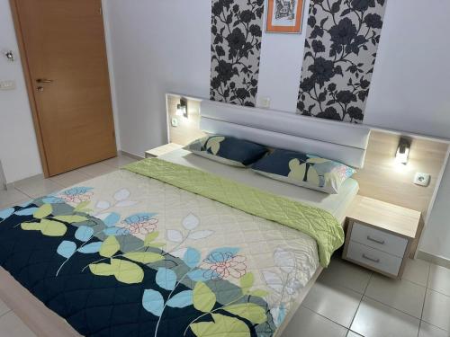 a bedroom with a large bed with a floral bedspread at Villa Jankuloski in Ohrid