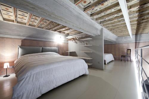 - une chambre avec un grand lit blanc et un bureau dans l'établissement La Casetta, à Tarquinia