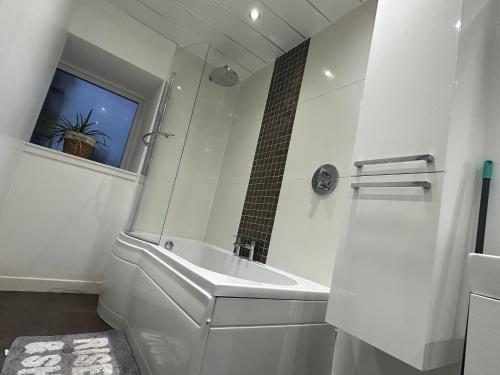 baño blanco con lavabo y ventana en Seaside Home, en Ardeer Square