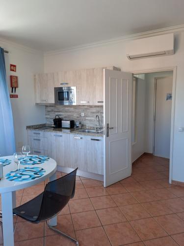 a kitchen with a table and a white table and chairs at Lovely new House - Guests Apartments in Olhão