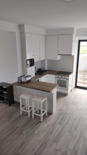 a kitchen with a counter and two stools at Costa do Moinho in Horta