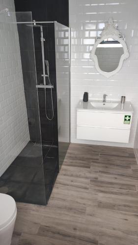 a bathroom with a shower and a sink and a toilet at Costa do Moinho in Horta