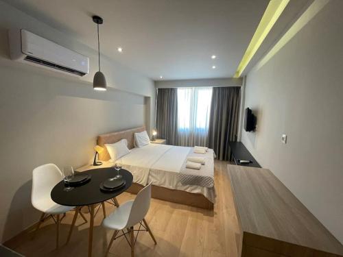 a bedroom with a bed and a table and chairs at Ladadika Deluxe Studio in Thessaloniki