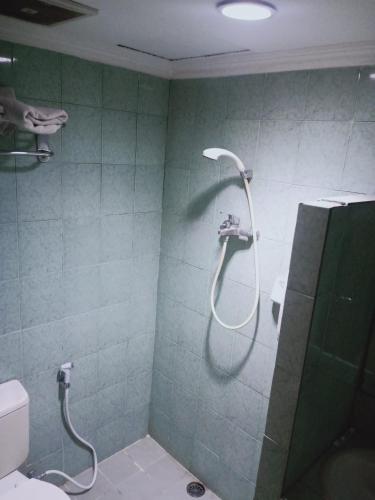a bathroom with a shower and a toilet at Puri Mega Hotel in Jakarta
