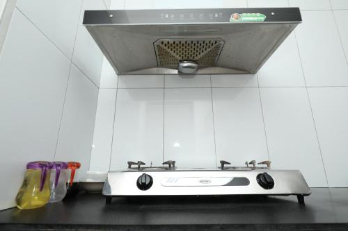 a stove top oven in a kitchen with a microwave at Tropical Plaza Apt in Nadi