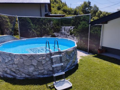 basen na dziedzińcu ze ścianą skalną wokół niego w obiekcie Kuca za odmor BARE vacation house w mieście Hadžići