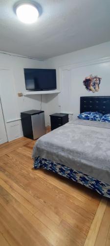 a bedroom with a bed and a flat screen tv at Cozy, spacious and peaceful in Providence