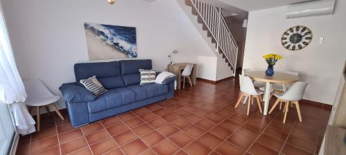 a living room with a blue couch and a table at Siente el relax. in Alcossebre