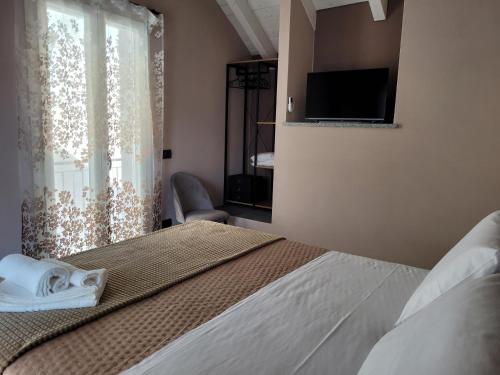 a bedroom with a bed with a television and a window at Al Dolce Vita in Stresa