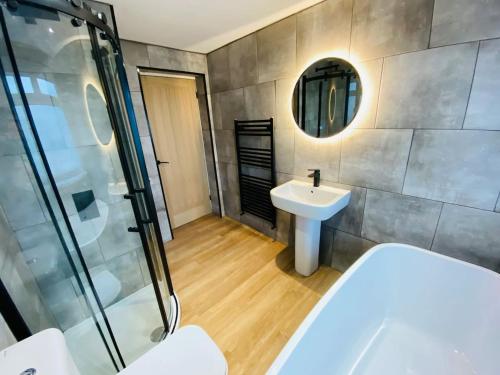 uma casa de banho com uma banheira, um lavatório e um chuveiro em Bluebell Cottage Heritage Town nr Brecon Beacons with hot tub em Blaenavon