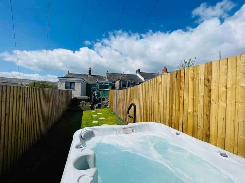a bath tub in front of a wooden fence at HOT TUB - Miners Cottage - edge of Brecon Beacons National Park - Heritage Town in Blaenavon
