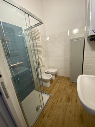 uma casa de banho com uma cabina de duche em vidro e um WC. em La Piazzetta 2 0 em LʼAquila