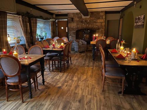 a restaurant with wooden tables and chairs and candles on them at HOT TUB - Miners Cottage - edge of Brecon Beacons National Park - Heritage Town in Blaenavon