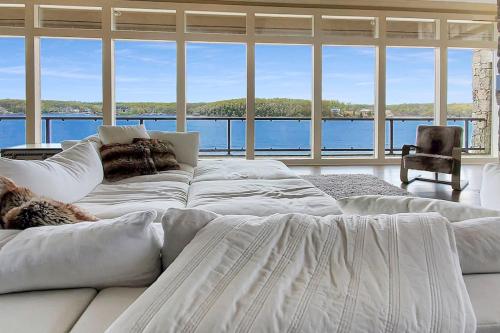 Un sofá blanco en una sala de estar con una ventana grande. en Iconic Glass Mansion - Huge Views - Best Location, en Osage Beach