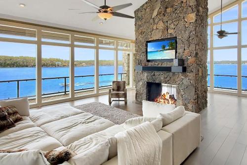a living room with a couch and a fireplace at Iconic Glass Mansion - Huge Views - Best Location in Osage Beach