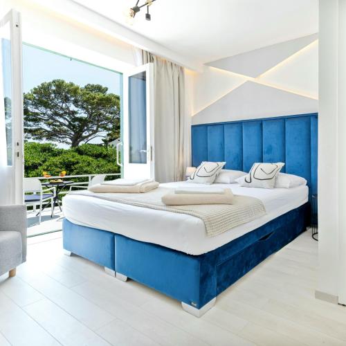 um quarto com uma cama grande e uma cabeceira azul em Aurora Beachfront Luxury Rooms&Suites em Brela