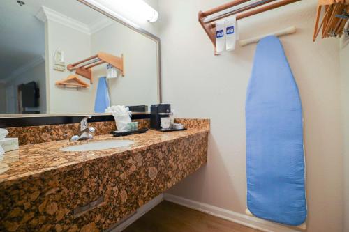 ein Badezimmer mit einem Waschbecken und einem großen Spiegel in der Unterkunft Best Western Heritage Inn in Bakersfield