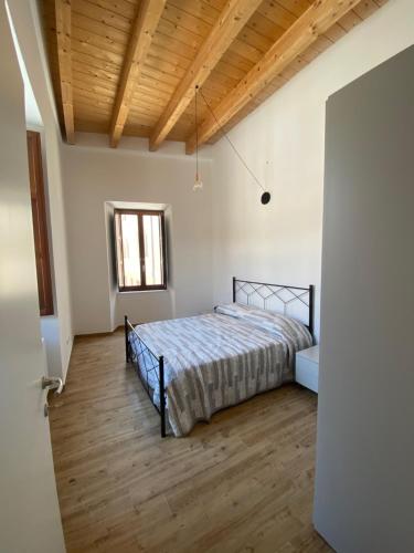 um quarto com uma cama e piso em madeira em La Piazzetta 2 0 em LʼAquila