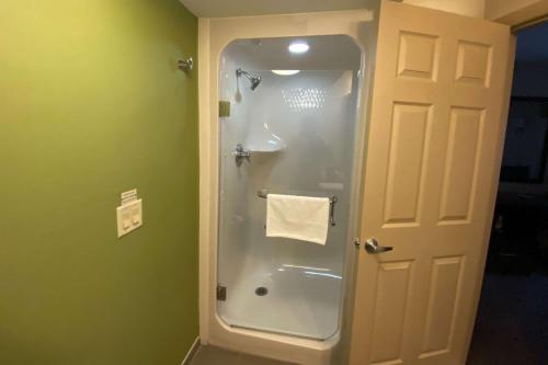 a shower stall in a bathroom with green walls at Sleep Inn & Suites Niantic North in Niantic
