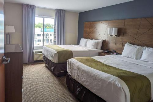 a hotel room with two beds and a window at Quality Inn & Suites Northampton - Amherst in Northampton