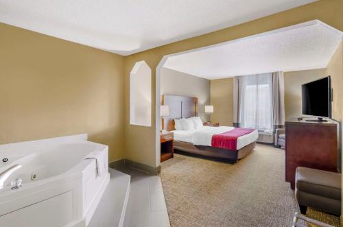 - une chambre d'hôtel avec un lit et une baignoire dans l'établissement Comfort Inn & Suites Christiansburg I-81, à Christiansburg