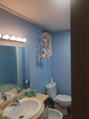 a bathroom with a sink and a toilet and a mirror at Apartamentos Catalunya in Platja  d'Aro