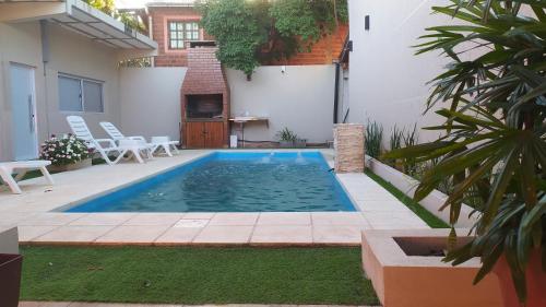a swimming pool in the backyard of a house at Departamento moderno con pileta in Puerto Iguazú
