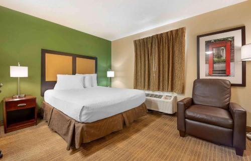 a hotel room with a bed and a chair at Extended Stay America Suites - Indianapolis - Northwest - College Park in Indianapolis