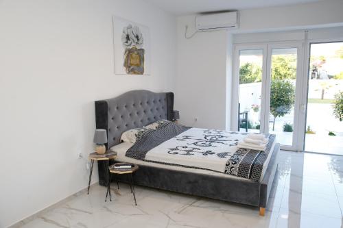 a bedroom with a large bed with a metal headboard at Reshkov Pool Apartments in Gevgelija