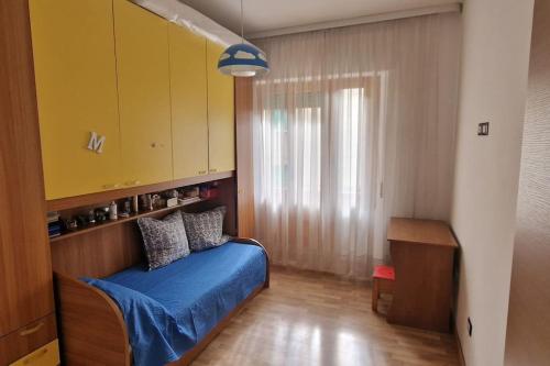 a bedroom with a blue bed and a yellow cabinet at Punto Zero in San Giovanni Valdarno