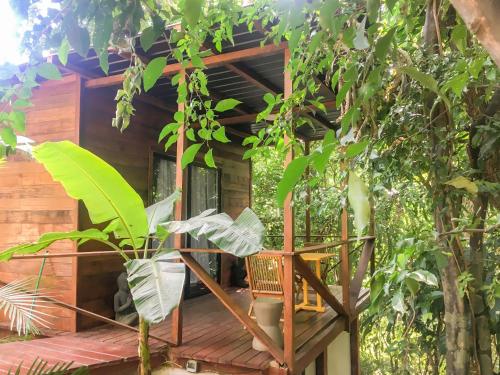 a tree house with a wooden porch and a chair at Hostel-Island Paradise, Saboga Lodge and Villa Noelia in Panama City