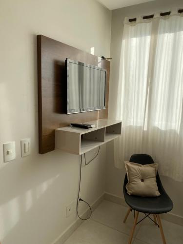 a living room with a tv and a chair at Everest Flat Service in Caldas Novas