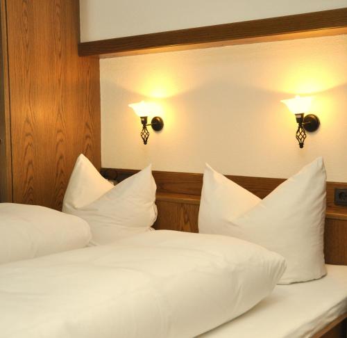 two beds in a room with white pillows at Auf der Sonnenseite in Schattwald