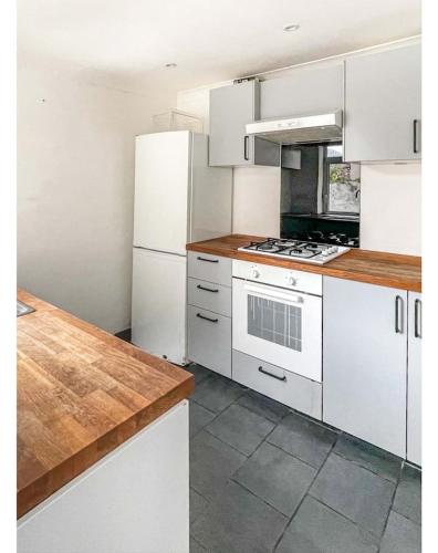 a kitchen with white cabinets and a stove top oven at Private room with Netflix in Litherland