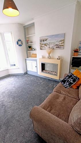 a living room with a couch and a fireplace at Private room with Netflix in Litherland