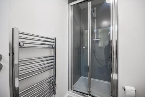 a shower with a glass door in a bathroom at Stylish Suite with free parking in Manchester