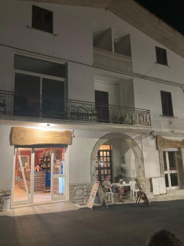 a white building with a table and a balcony at Salinello Beer Baita Affittacamere in Le Ripe